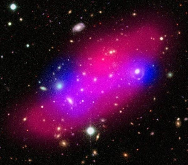 Composite image of the Bullet Group showing galaxies, hot gas (shown in pink) and dark matter (indicated in blue). Dark photons could never explain this gravity alone. Image credit: ESA / XMM-Newton / F. Gastaldello (INAF/IASF, Milano, Italy) / CFHTLS