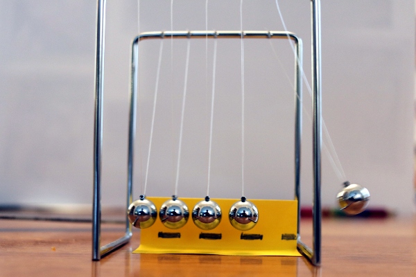 SteelyKid's toy Newton's cradle in mid-swing.