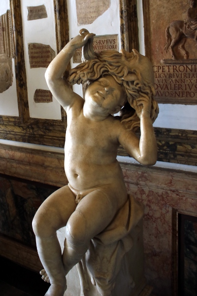 A statue of a small child playing with a theater mask from the Musei Capitolini.