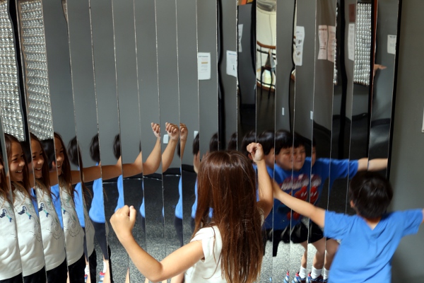 The kids in front of an array of mirrors at the Long Island Children's Museum.
