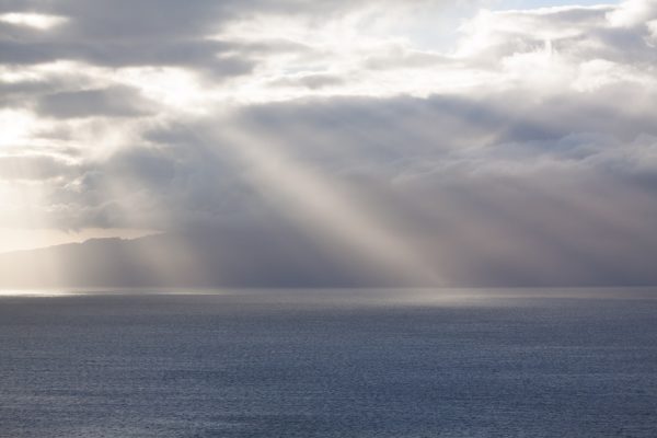 Public domain photo from Pixabay user stux, via https://pixabay.com/en/clouds-horizon-sunbeam-sea-ocean-571552/.