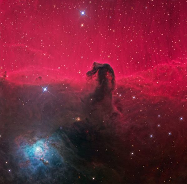The dark Horsehead Nebula, with the red emission nebula behind it and the blue reflection nebula where new stars live at its base. Image credit: Ken Crawford, under a c.c.a.-s.a.-3.0 license.
